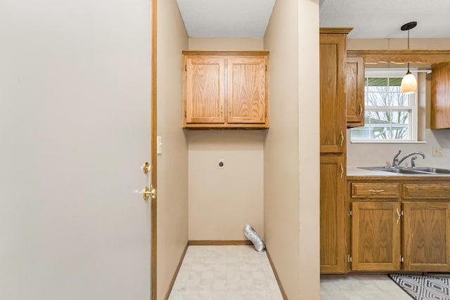 clothes washing area featuring cabinets, hookup for an electric dryer, and sink