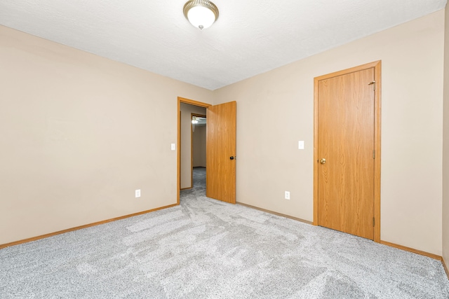 unfurnished room with a textured ceiling and light colored carpet