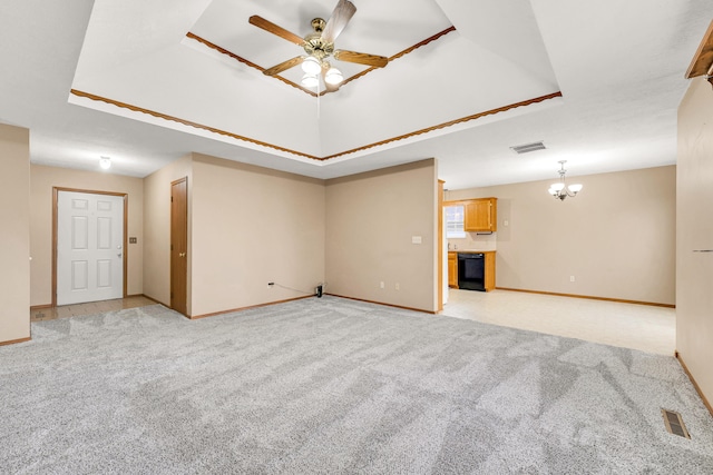 unfurnished living room featuring light colored carpet, ceiling fan with notable chandelier, and a tray ceiling