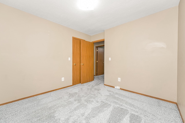 empty room featuring a textured ceiling and light carpet