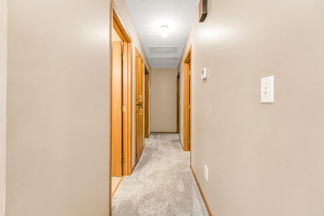 hall with a textured ceiling and light carpet