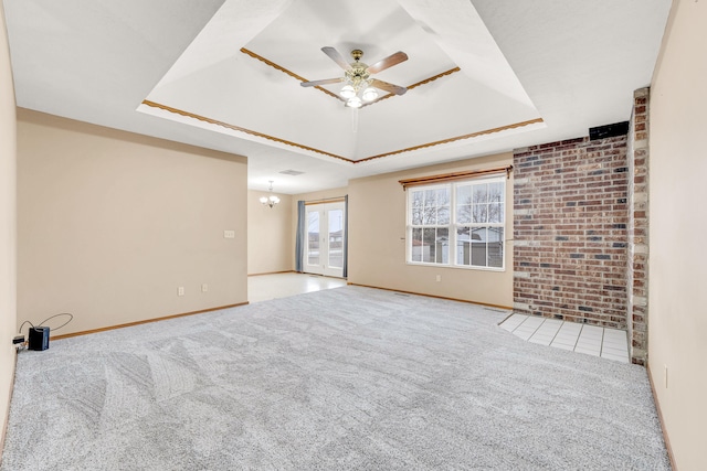 unfurnished living room featuring brick wall, ceiling fan with notable chandelier, light carpet, and a raised ceiling