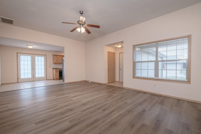 unfurnished living room with french doors, light hardwood / wood-style flooring, and ceiling fan