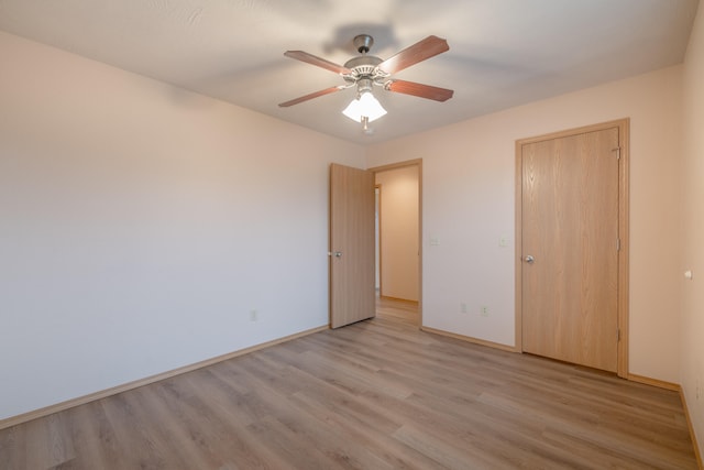 unfurnished bedroom with ceiling fan, a closet, and light wood-type flooring