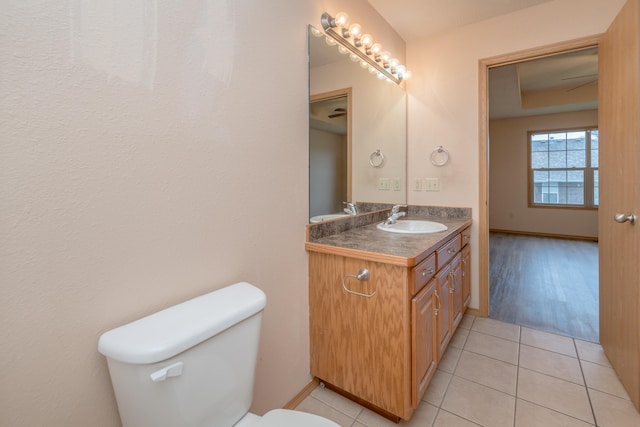 bathroom with toilet, vanity, and tile patterned flooring