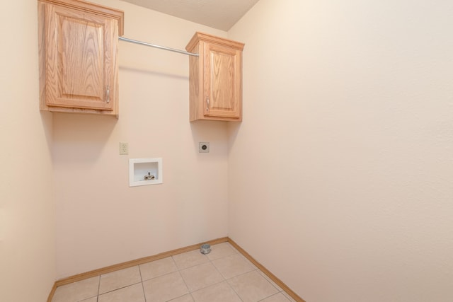 clothes washing area with hookup for an electric dryer, hookup for a washing machine, cabinets, and light tile patterned floors