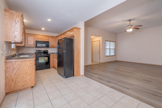 kitchen with sink, black appliances, light brown cabinets, ceiling fan, and light wood-type flooring