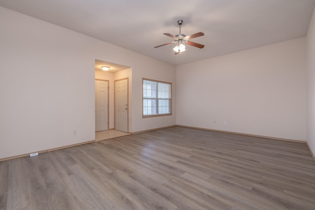 empty room with ceiling fan and light hardwood / wood-style flooring