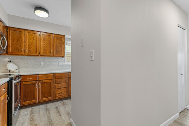 kitchen featuring tasteful backsplash, light hardwood / wood-style floors, and stainless steel appliances