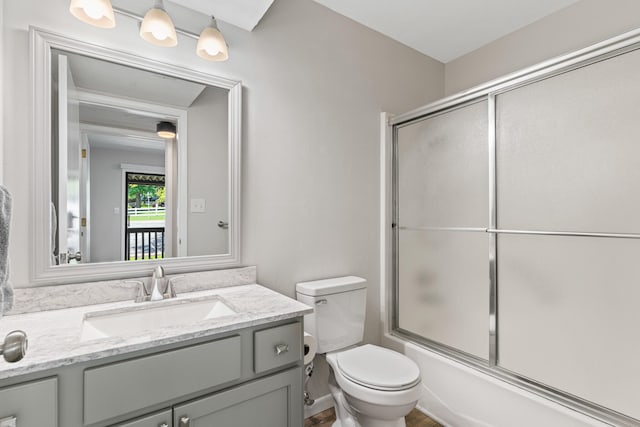 full bathroom with toilet, combined bath / shower with glass door, and vanity