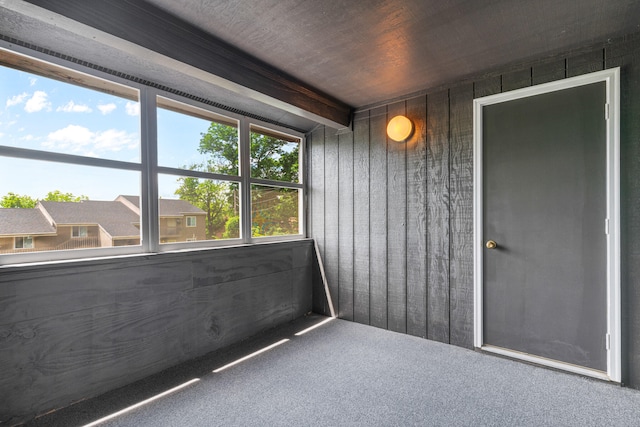 unfurnished sunroom with beamed ceiling