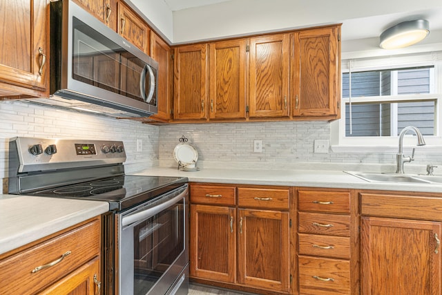 kitchen with decorative backsplash, stainless steel appliances, and sink