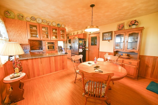 dining space featuring wooden walls and light hardwood / wood-style floors