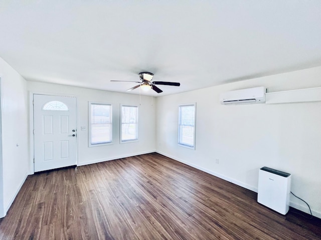 foyer entrance with ceiling fan, a wall unit AC, and dark hardwood / wood-style floors