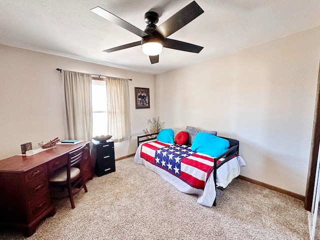 bedroom featuring a textured ceiling, light colored carpet, and ceiling fan