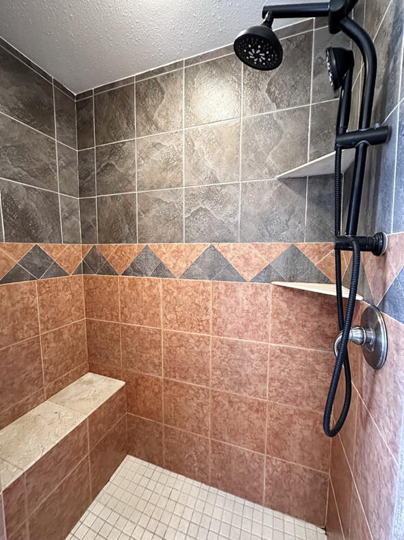 bathroom featuring a textured ceiling and a tile shower