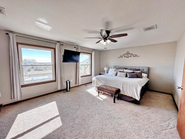 carpeted bedroom featuring a textured ceiling and ceiling fan