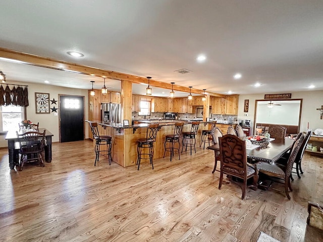 dining room with light hardwood / wood-style floors and ceiling fan