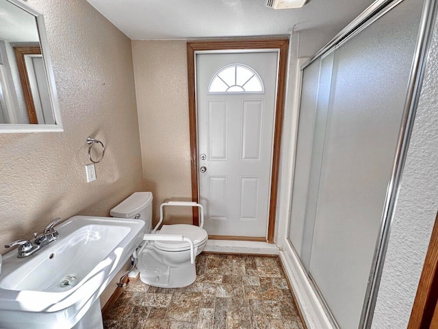 bathroom with walk in shower, toilet, and sink