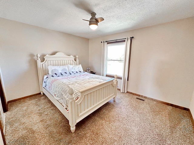 bedroom with a textured ceiling, carpet, and ceiling fan