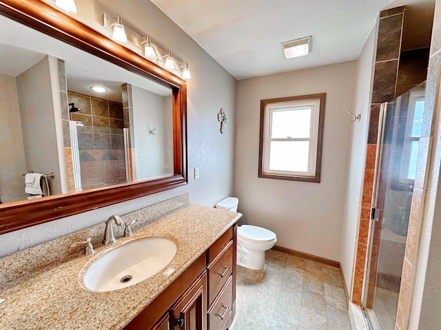 bathroom with toilet, vanity, and an enclosed shower