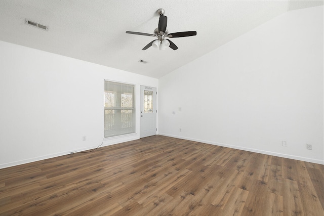 spare room featuring dark hardwood / wood-style flooring, lofted ceiling, a textured ceiling, and ceiling fan