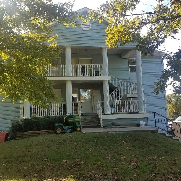 rear view of property featuring a lawn