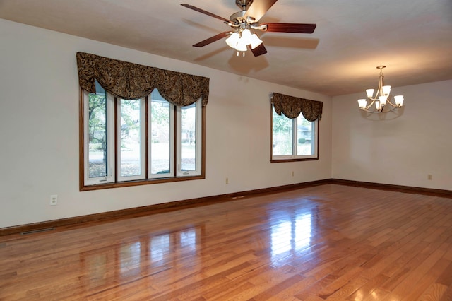 unfurnished room with light wood-type flooring and ceiling fan with notable chandelier