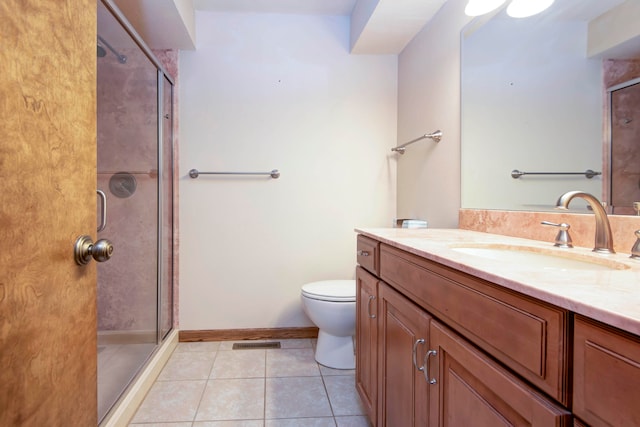 bathroom with tile patterned flooring, an enclosed shower, vanity, and toilet