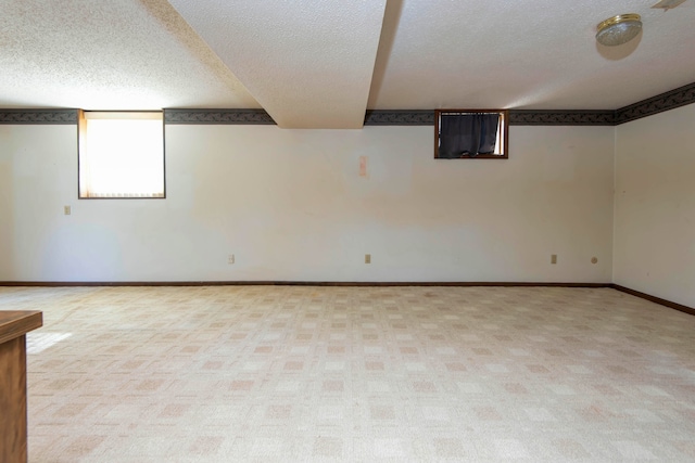 basement with a textured ceiling and light carpet