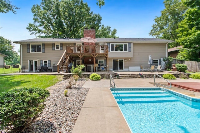 back of property featuring a swimming pool side deck and a patio area