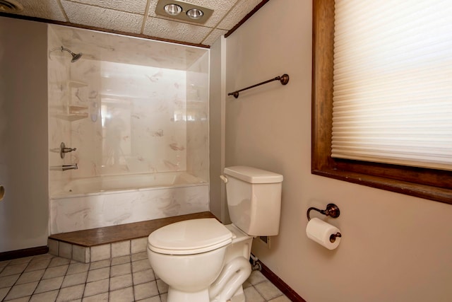 bathroom with a drop ceiling, tile patterned flooring, toilet, and shower / bathtub combination