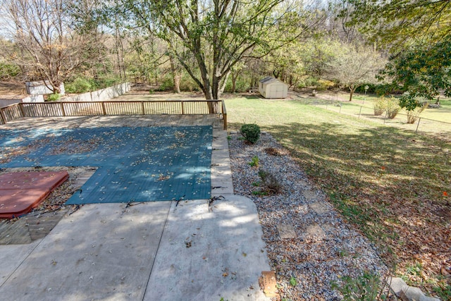 view of pool with a storage unit and a yard