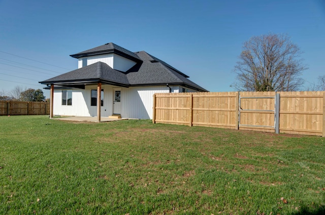 rear view of property featuring a lawn and a patio area