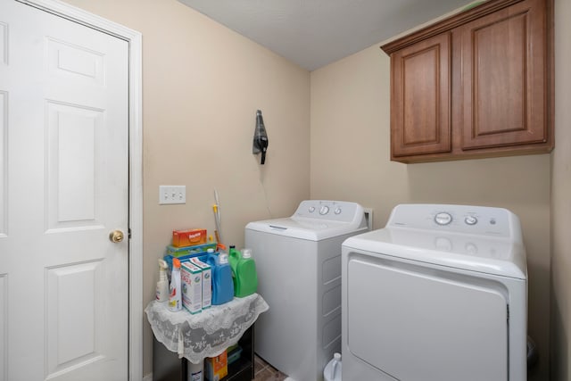 laundry room featuring cabinets and washing machine and dryer