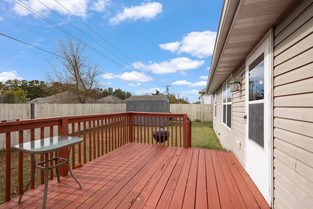 wooden deck featuring a storage unit and a yard