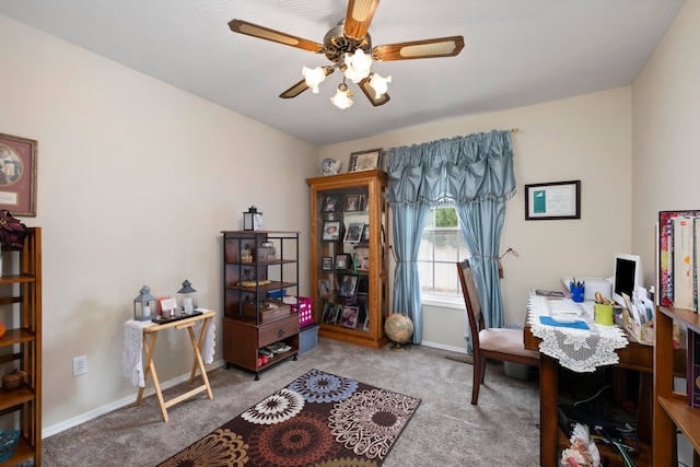 carpeted home office featuring ceiling fan