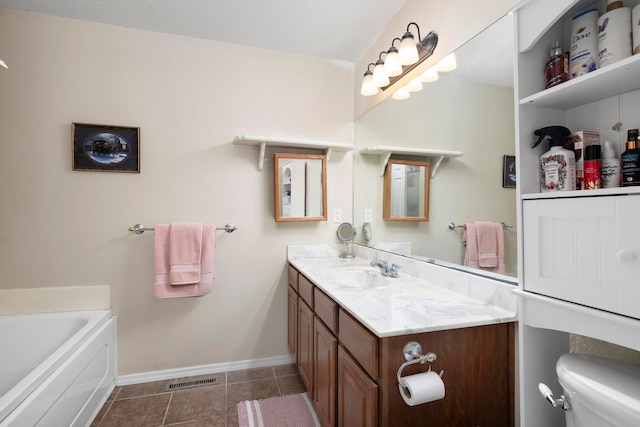 bathroom with vanity, a tub, tile patterned flooring, and toilet