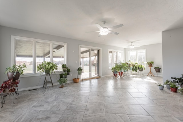unfurnished sunroom with ceiling fan