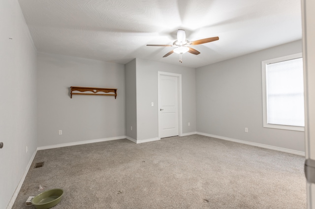 spare room featuring carpet flooring and ceiling fan
