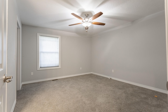 carpeted spare room with ceiling fan