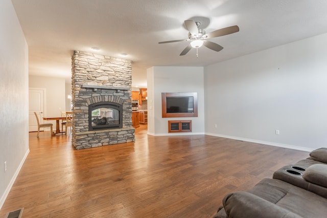 living room with a fireplace, wood-type flooring, and ceiling fan