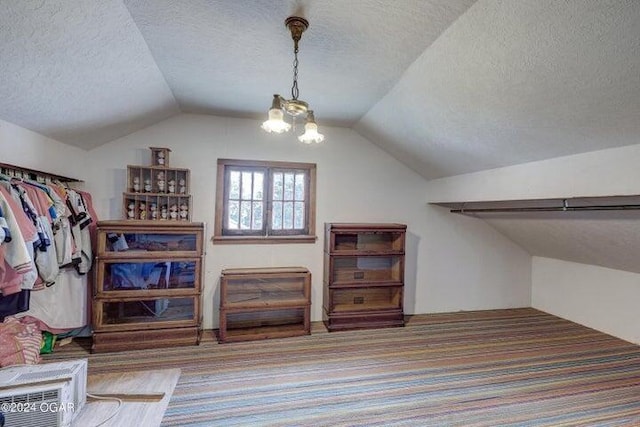 walk in closet with vaulted ceiling and an inviting chandelier