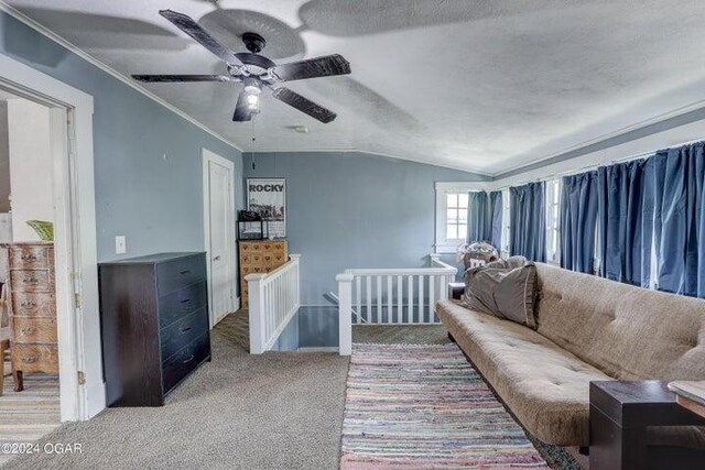 carpeted living room with ceiling fan, a textured ceiling, vaulted ceiling, and crown molding