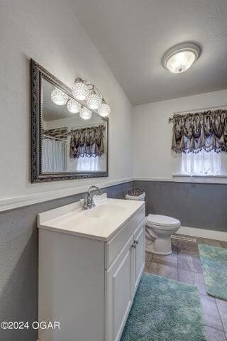 bathroom with tile patterned floors, vanity, and toilet