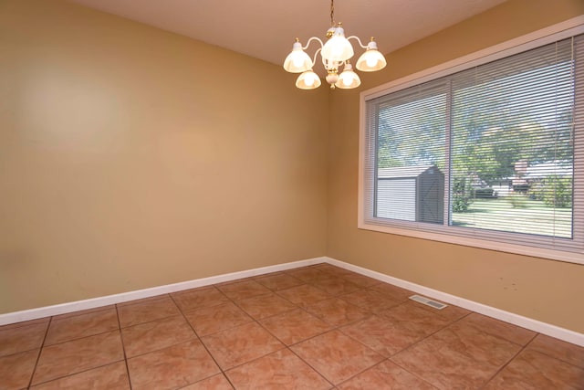 unfurnished room with an inviting chandelier and tile patterned floors