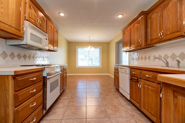 kitchen with white appliances, sink, pendant lighting, and tasteful backsplash