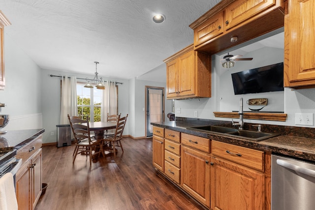 kitchen featuring stainless steel appliances, dark hardwood / wood-style flooring, a textured ceiling, sink, and pendant lighting