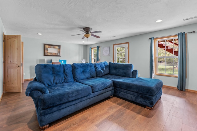 living room with hardwood / wood-style floors, ceiling fan, plenty of natural light, and a textured ceiling