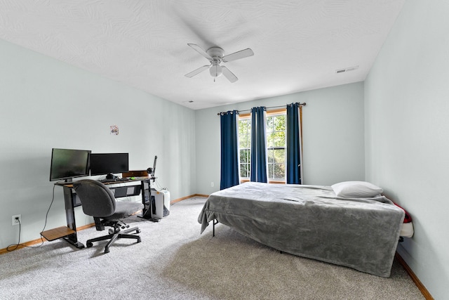 bedroom with a textured ceiling, carpet floors, and ceiling fan